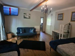 een woonkamer met een blauwe bank en een stoel bij The Pot in Pretoria