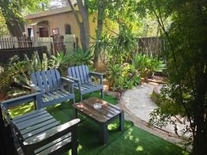 twee blauwe stoelen en een tafel in de tuin bij The Pot in Pretoria