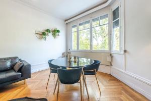 a living room with a table and chairs and a couch at ILOT - Appartement confortable près du lac in Annecy