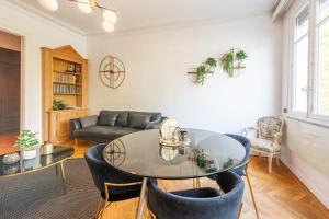a living room with a glass table and chairs at ILOT - Appartement confortable près du lac in Annecy
