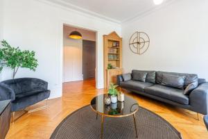 a living room with a couch and a table at ILOT - Appartement confortable près du lac in Annecy