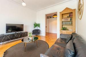 a living room with a couch and a tv at ILOT - Appartement confortable près du lac in Annecy +20 photos