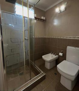 a bathroom with a toilet and a glass shower at Casita serrana in Villa Santa Cruz del Lago