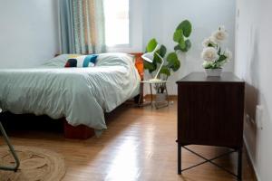 una camera da letto con un letto e un tavolo con dei fiori sopra di Green Haven - Modern Cozy Studio - Fast Wi-Fi - AC - Cocody a Abidjan