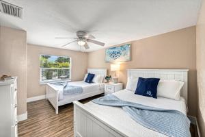 a bedroom with two beds and a ceiling fan at The Solaster in Siesta Key +74 photos