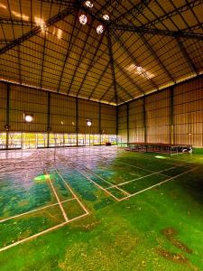 Un gimnasio vacío con suelo verde en un edificio. en Louis Backpackers Hostel, en Kochi
