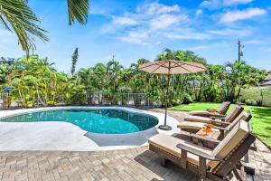 a swimming pool with two chairs and an umbrella at The Solaster in Siesta Key