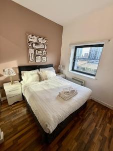 a bedroom with a large bed and a window at Bloom Apartments - City Centre - Gated Parking in Manchester
