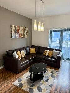 a living room with a leather couch and a table at Bloom Apartments - City Centre - Gated Parking in Manchester
