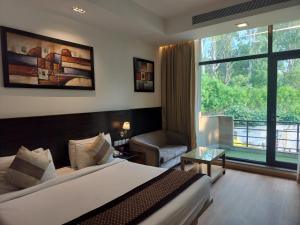 a hotel room with a bed and a large window at Stellar Resorts By Bel-La Monde, Rajokri, Near IGI Airport, Delhi in New Delhi