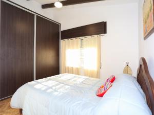 a bedroom with a large white bed with a wooden headboard at La Casa de los Pájaros in Tanti +16 photos