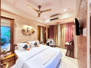 a bedroom with a large white bed and a mirror at Garden Veil Luxury Villa By Spacez in Mumbai
