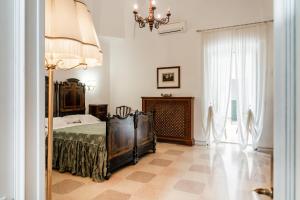 a bedroom with a bed and a chandelier at Palazzo Rodio in Ostuni +82 photos