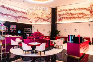 a lobby with tables and chairs and a chandelier at The St. Regis Doha in Doha