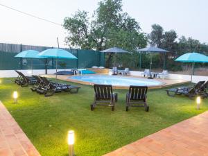 a group of chairs and umbrellas in front of a pool at Tavira Monte in Tavira
