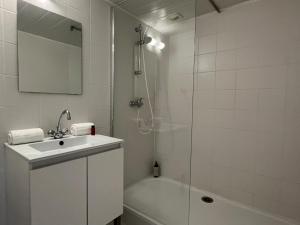 a white bathroom with a sink and a shower at 25m2 Grande Plage, hypercentre, balcon in Biarritz +10 photos