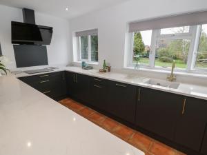 a kitchen with black cabinets and a sink at Harran in Peopleton +37 photos