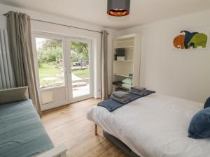 a bedroom with a bed and a sliding glass door at Harran in Peopleton