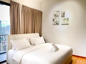 a white bed in a room with a window at Beacon Executive Suite with SkyPool 3BR 8pax Georgetown Penang in Georgetown