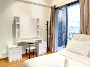 a bedroom with a bed and a desk and a window at Beacon Executive Suite with SkyPool 3BR 8pax Georgetown Penang in Georgetown