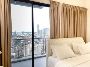 a bedroom with a bed and a large window at Beacon Executive Suite with SkyPool 3BR 8pax Georgetown Penang in Georgetown