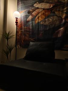une chambre avec un lit et une lampe avec un tableau dans l'établissement 拾己微光輕旅, à Jincheng 3 autres photos