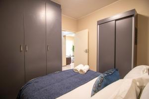 Un dormitorio con una cama con dos toallas encima. en Waterfall Ridge Luxurious Apartment 2 Backup Power, en Midrand 25 fotos más
