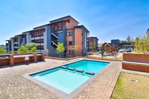 una gran piscina frente a un edificio en Waterfall Ridge Luxurious Apartment 2 Backup Power, en Midrand
