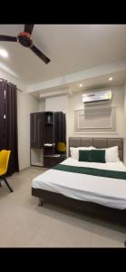 a bedroom with a large bed and a yellow chair at Hotel Lavish Inn in Jāmb