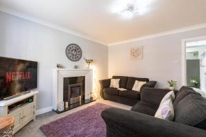 a living room with a couch and a fireplace at Townhouse Harbour Retreat in Scarborough
