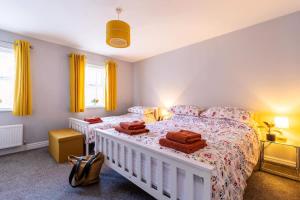 a bedroom with two beds and yellow curtains at Townhouse Harbour Retreat in Scarborough
