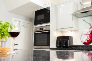 a kitchen with a glass of wine on a counter at Townhouse Harbour Retreat in Scarborough +14 photos