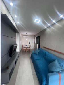 a bedroom with a blue bed and a table at Residencial Acquamare in Praia Grande