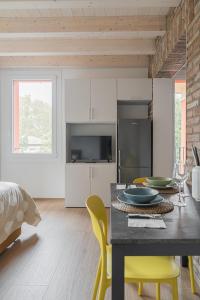 a kitchen with a table and yellow chairs in a room at LaNica Maison in Castelfranco Emilia