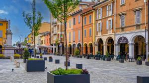 a city street with buildings and plants in pots at LaNica Maison in Castelfranco Emilia