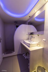 La salle de bains est pourvue d'un lavabo et d'un plafond bleu. dans l'établissement Argiris Studios, à Kamari