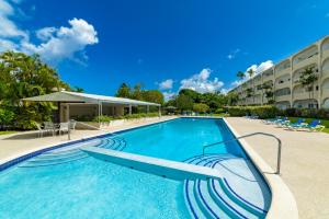 a swimming pool at a resort with chairs and a building at Rum Runner - Golden View 328 in Saint James