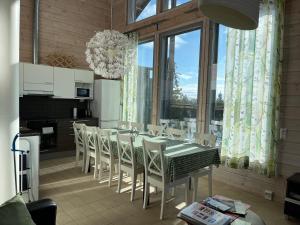 a dining room with a table and white chairs at Villa Castillo in Saariselka