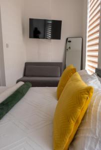 a bedroom with a bed with yellow pillows and a couch at Dalston Luxe Studios in London +79 photos