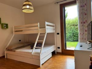 a bunk bed with a ladder in a room with a window at Sweet Home en Arquá Petrarca in Arqua Petrarca