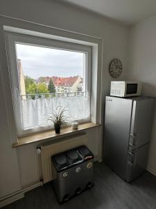 eine Küche mit einem Kühlschrank und einem Fenster in der Unterkunft SunshineLiving Maschsee in Hannover