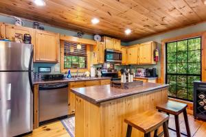 een keuken met houten kasten en een roestvrijstalen koelkast bij Gunny's Cabin in Stewart Mill