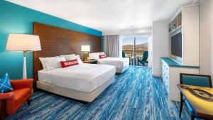 a hotel room with two beds and a television at Compass by Margaritaville Hotel Pigeon Forge in Pigeon Forge