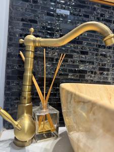 a brass faucet on a table in front of a wall at Laya Old Town Blue in Bucharest
