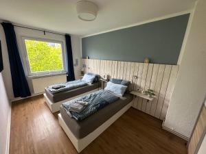 zwei Betten in einem Zimmer mit Fenster in der Unterkunft SunshineLiving Maschsee in Hannover