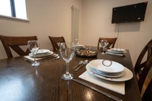 una mesa de madera con platos y vasos encima en Rookery Park Barns 6, en Carlton Colville 10 fotos más