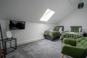 Una sala de estar con un sofá, una cama y un televisor. en Rookery Park Barns 6, en Carlton Colville