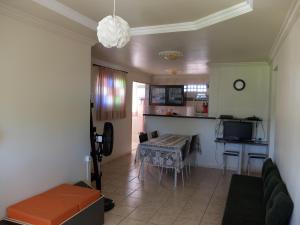 a living room with a table and a kitchen at Cobertura Porto de Galinhas in Porto De Galinhas