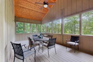 a screened in porch with a table and chairs at Bear Creek Cabin in Sapphire