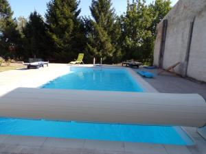 a large swimming pool with blue water in a yard at La Grange in Dieulivol